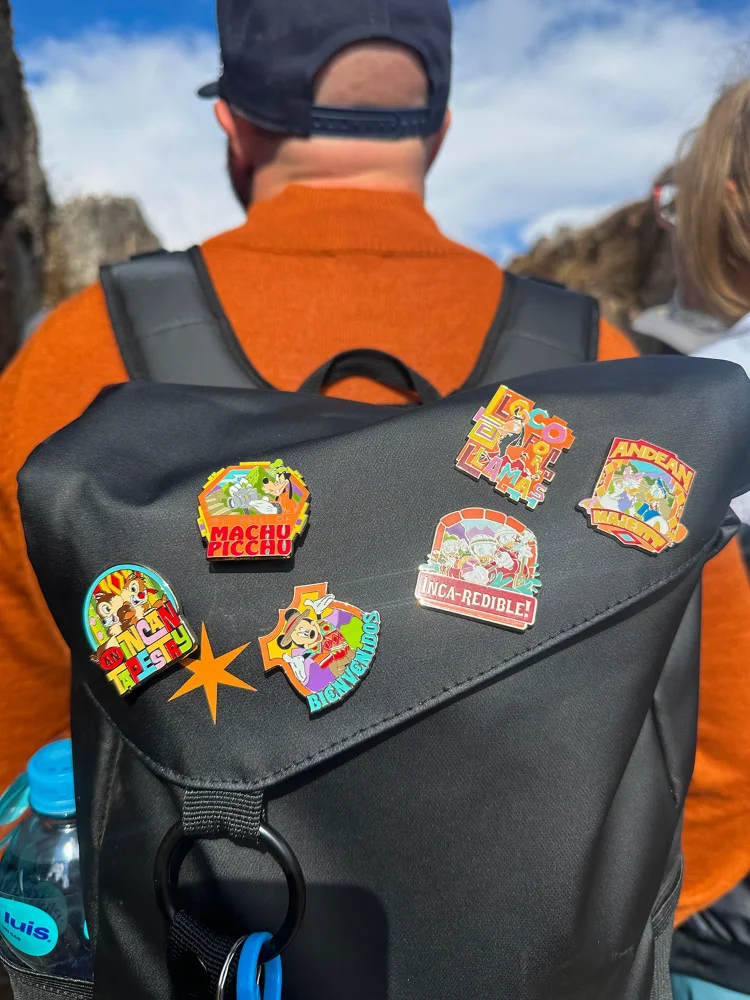 Adventures by Disney trip pins on a backpack