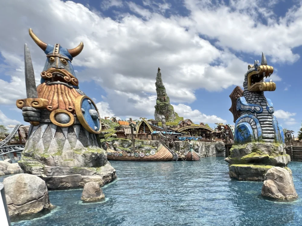 A Viking village and dragon figures beside the water